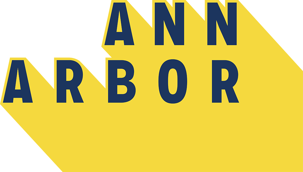 The words "ANN ARBOR" appear in bold navy blue letters on a yellow background, with long, yellow shadows extending behind each letter.