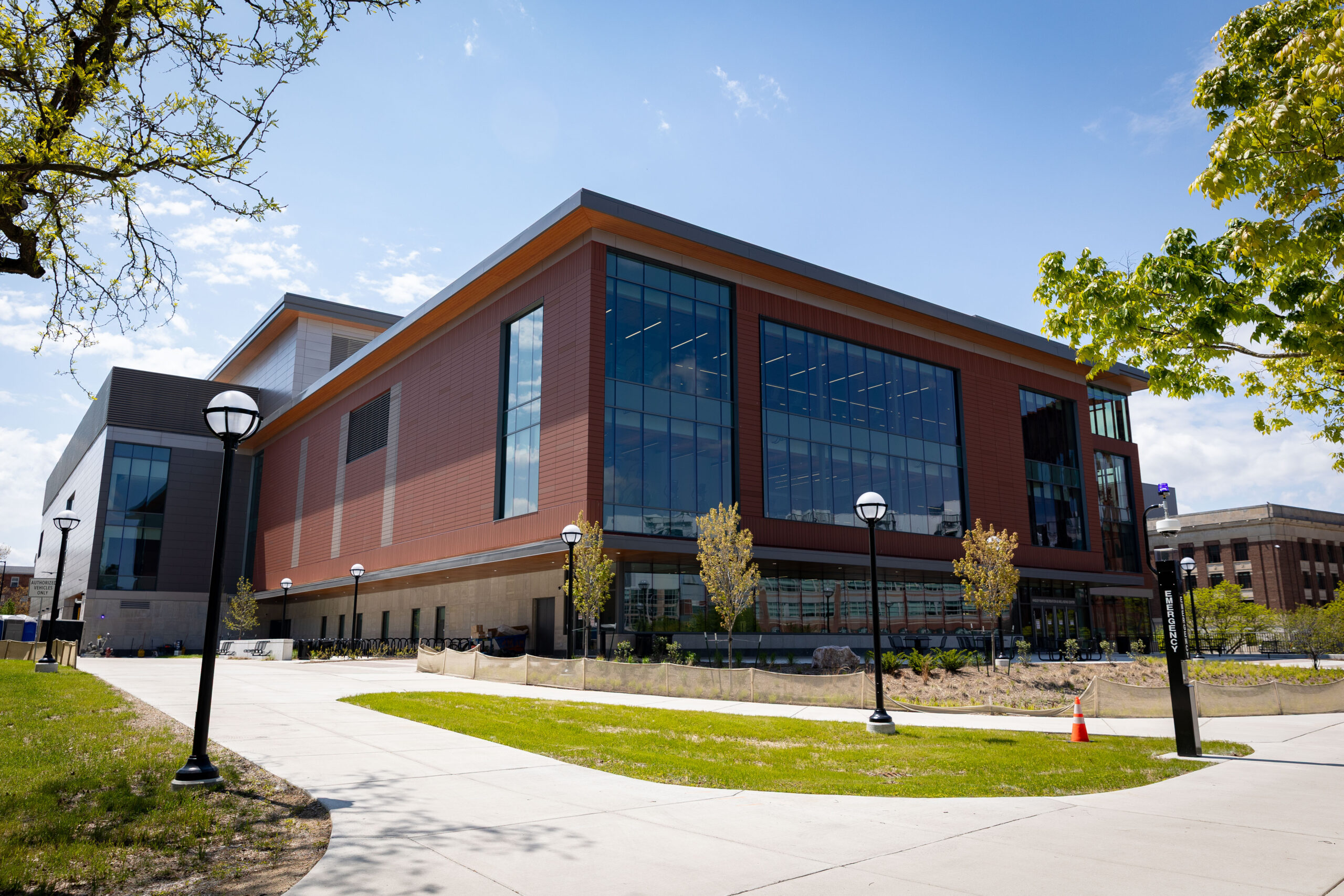 Outside of the Hadley center, with brick and large windows, with walkways and green grass in the foreground.