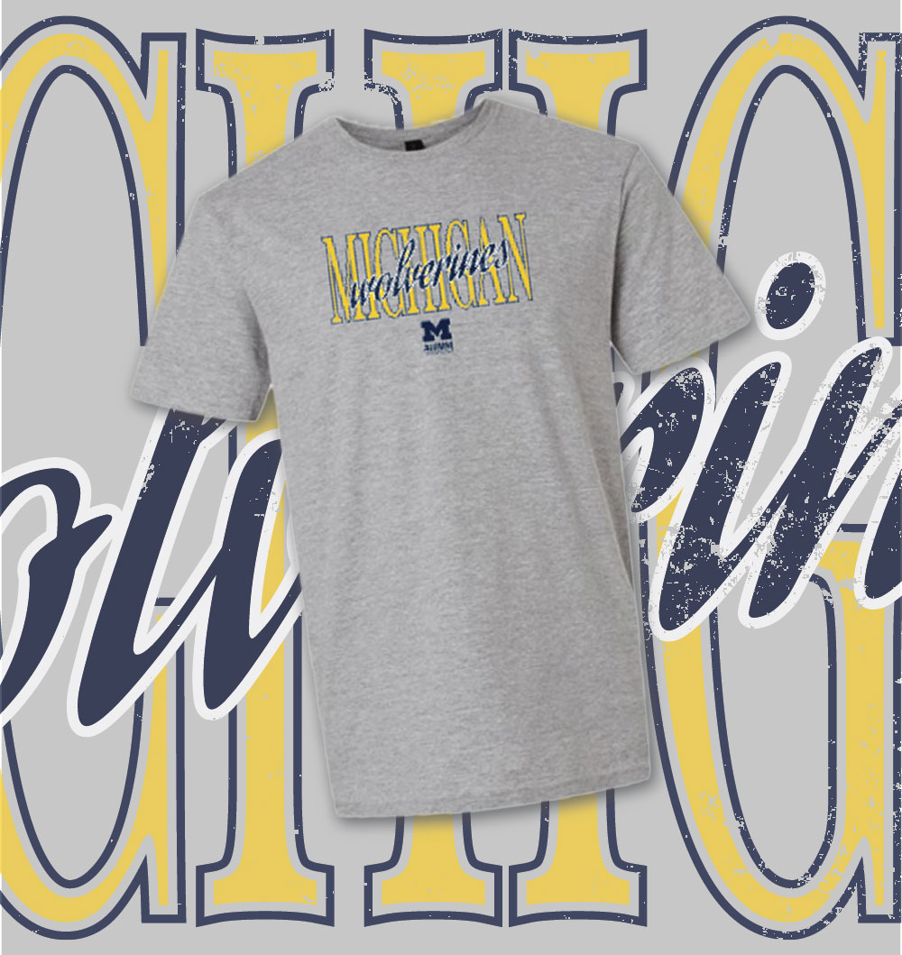 Gray Michigan Wolverines T-shirt displayed on a background with large maize and blue Michigan Wolverines text.