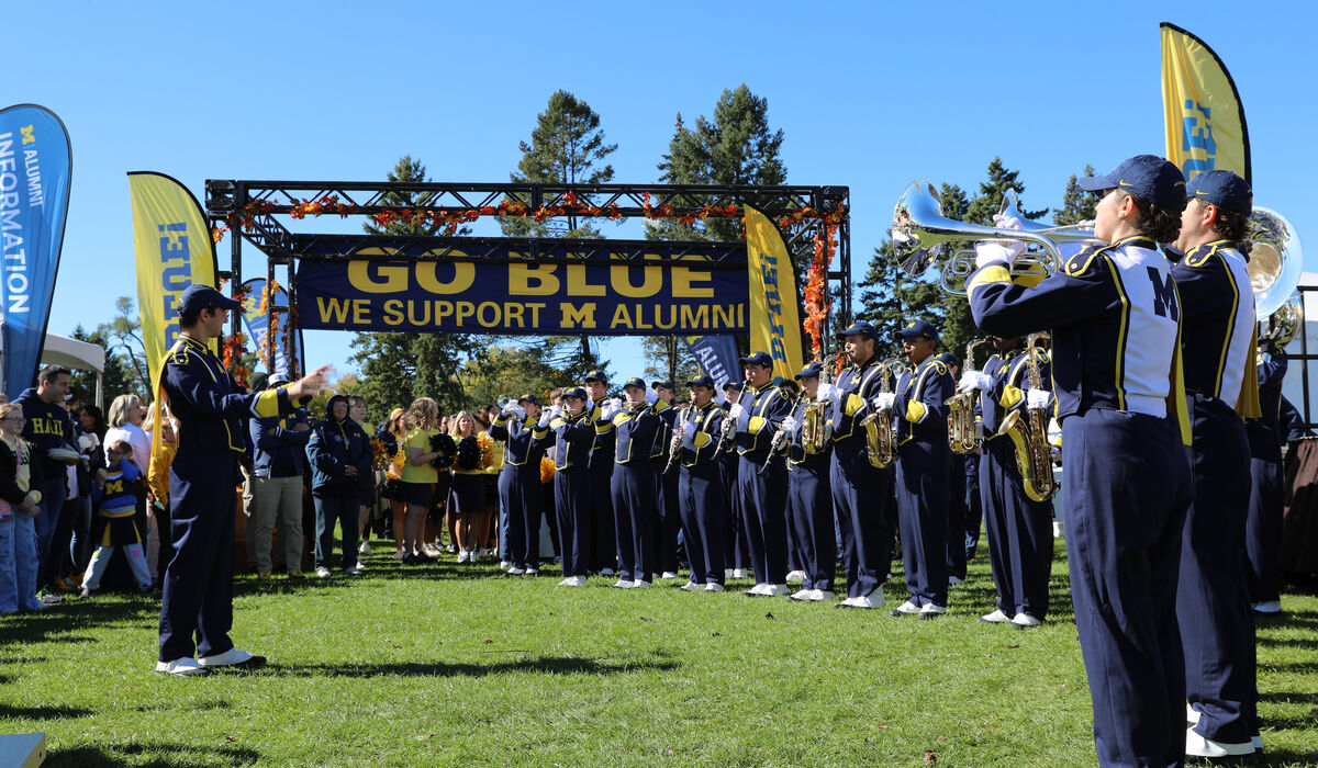 The Michigan fanfare band plays at a tailgate
