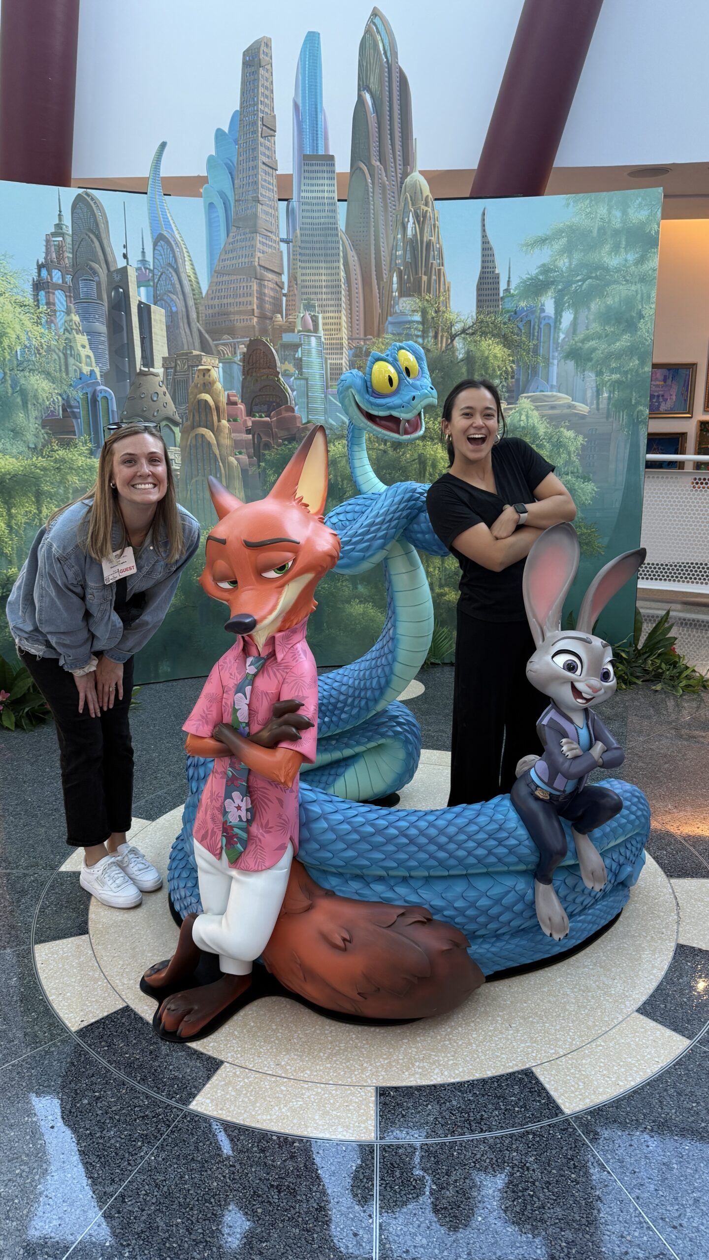 Amy Tseng, in all black, poses with statue characters from "Zootopia"