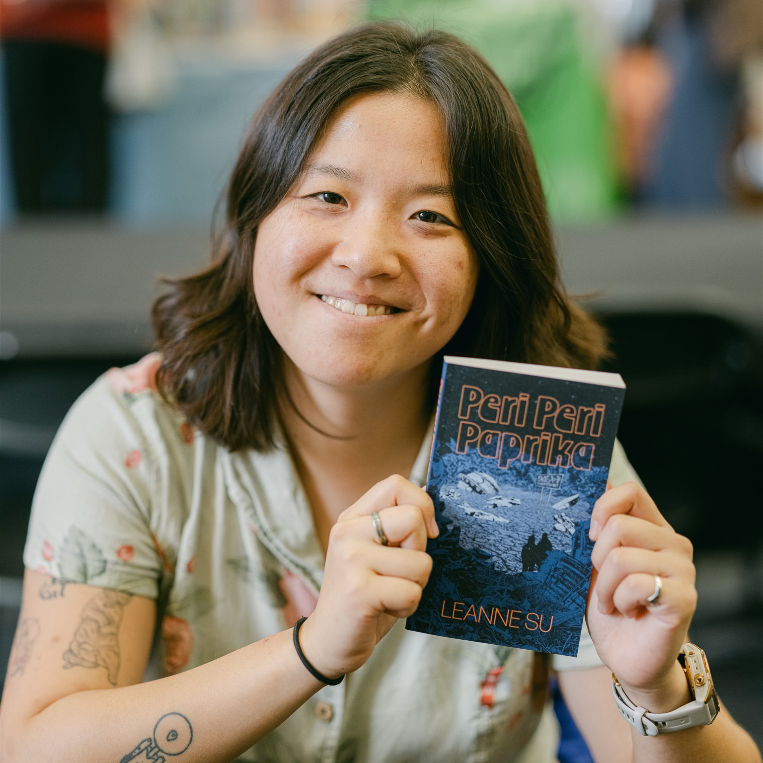 Leanne Su poses with her book, Peri Peri Paprika.