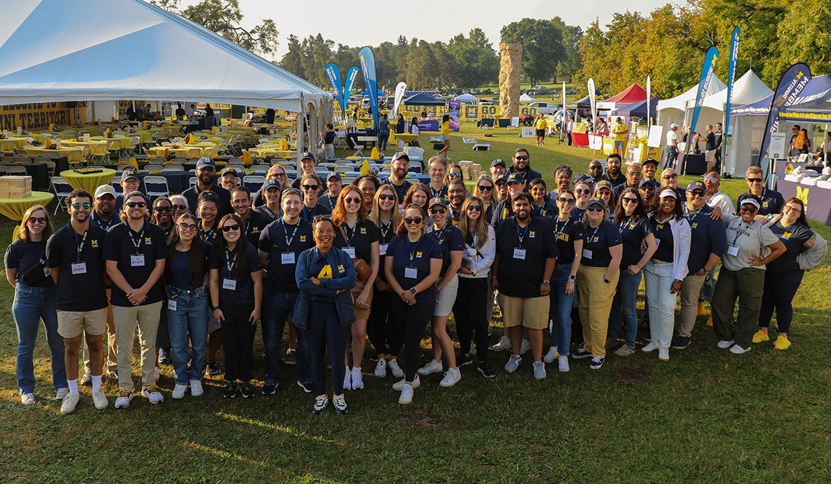 The staff of the Alumni Association of the University of Michigan poses for a photo before the 2024 Alumni Territory Homecoming Tailgate.