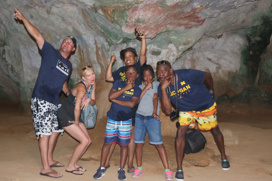 Dr. Kelly Martin, ’91, her husband, Andre, and their children pose, with friends, inside the Quadirikiri Caves on an extreme island tour in Aruba.
