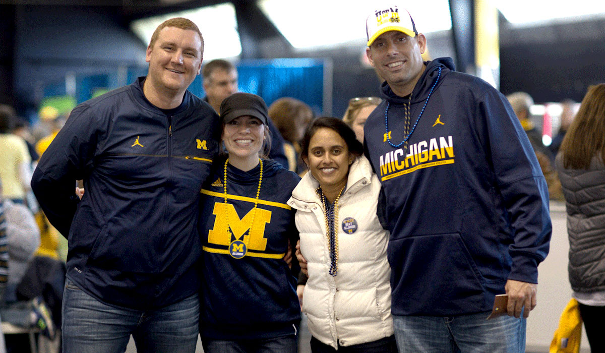 Michigan alumni pose for a photo at the annual Homecoming Tailgate