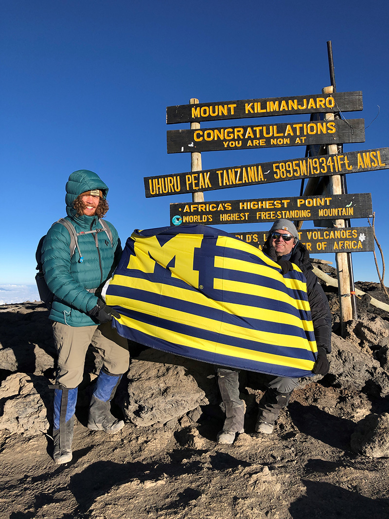 Over the summer, Coleman Harris (left) and his uncle, Jon, ’94, flew the Maize and Blue at the top of Mount Kilimanjaro.