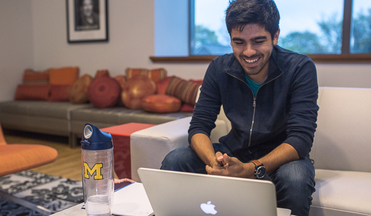 Person smiles as they look at a MacBook screen