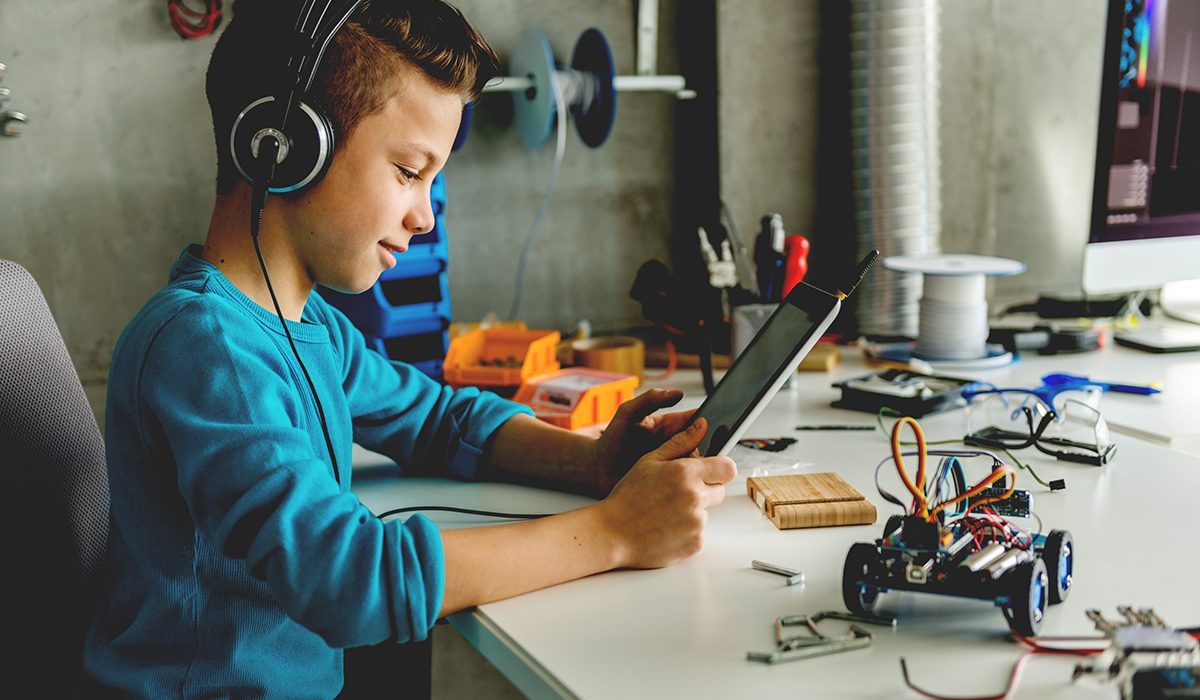 Teenage Boy With Headphones Holding Digital Tablet