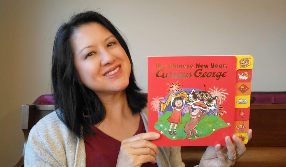 Maria Wen Adcock poses with her debut book, "It's Chinese New Year, Curious George."