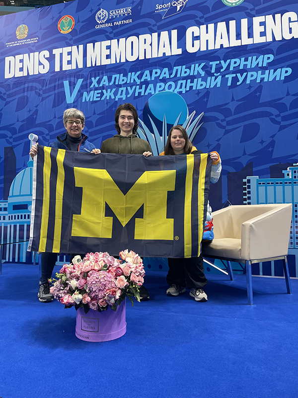 Elizabeth Walker (BMus ’82, MBA ’84, current student Matthew Sperry, and Sara Walker, BS ’12, BSE ’12, MS ’16, MD ’18, were proud to carry the Maize and Blue after Sperry competed in the 2024 Denis Ten Memorial Challenge in Kazakstan, representing Finland in ice dancing with his skate partner Daniela Ivanitskiy (not pictured). Walker served as the Team USA doctor.