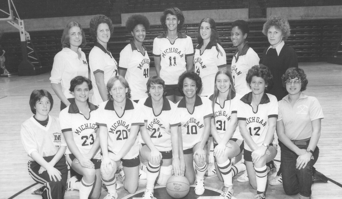 The 1976-77 U-M Women's Basketball team, including Lydia Sims (front row, fourth from right), pose for a team photo on the basketball court