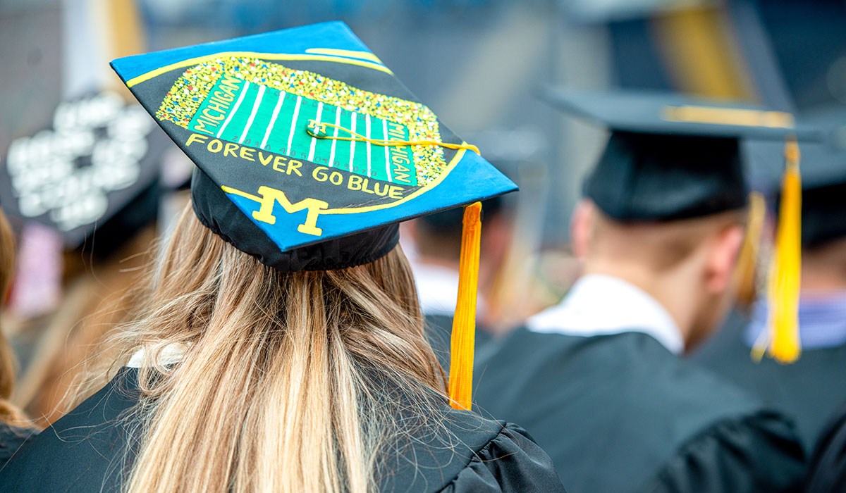 Graduation cap with an illustration of the Michigan football field, a block M, and text that says "Forever Go Blue"