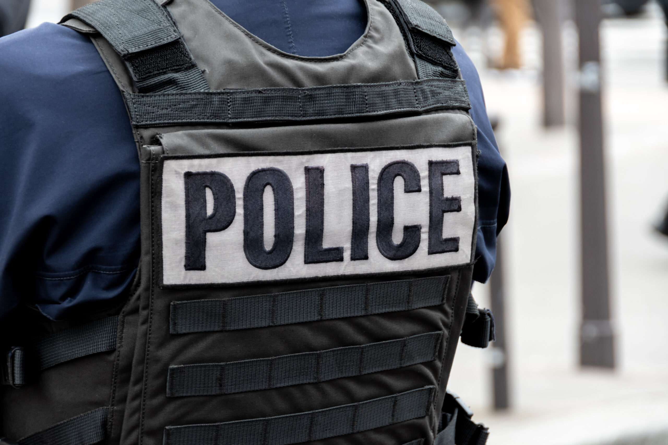 Close Up 'POLICE' Marking Written On The Back Of A Bulletproof Vest Worn By A French Police Officer