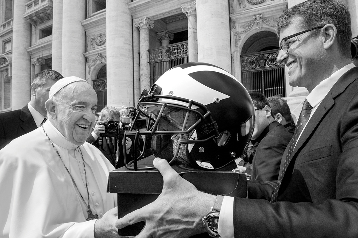 Harbaugh presents the legendary winged helmet to Pope Francis following a public papal mass in St. Peter’s Square.
