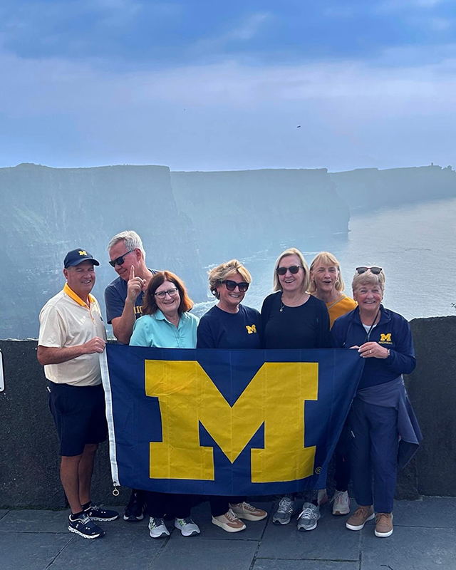 Seven proud U-M alumni traveled to their ancestral home of Ireland in September and posed with the block M flag at the Cliffs of Moher, among other iconic locations they visited. From left to right are: Dennis Drinan, ’86; Dave Drinan, ’80; Lynn Drinan, ’81; Patty Drinan Neterer, ’83, PHARMD’84; Kathleen J. Drinan, ’78; Jean Drinan Osborn, ’73; and Peg Hahn, ’71.