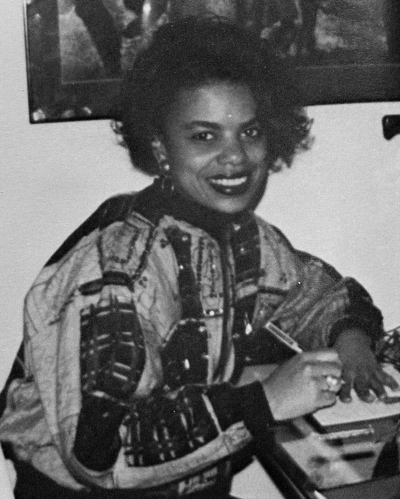 Black-and-white yearbook photo of Corie Pauling sitting at a desk, writing in a notebook.