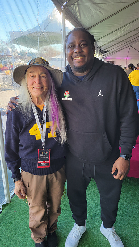 Jana Smith, ’73, MSE’78, completed a full-circle moment when she snapped a picture with Wolverine football’s Denard Robinson, ’13, in the lead-up to the Rose Bowl in Pasadena, California. Jana’s father, Kenneth L. Smith, ’49, played football for U-M and Jana wore his sweater for this photo and the bowl game.