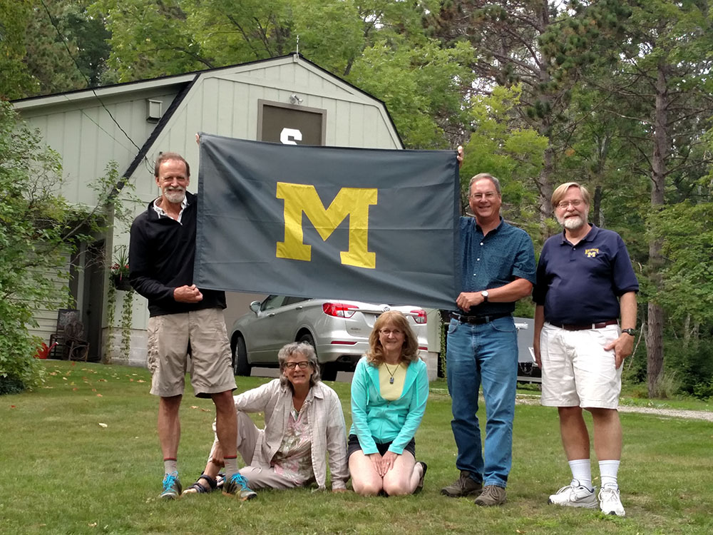 A group of friends reuniting in northern Michigan couldn’t pass on a chance to one-up a neighbor, whose barn sports a Spartan logo. From left to right are Pete Westcott, ’79, Sue Anderson, ’77, Cynthia Boettner, ’80, Jeff Boettner, ’80, and Craig Kuesel, ’79.