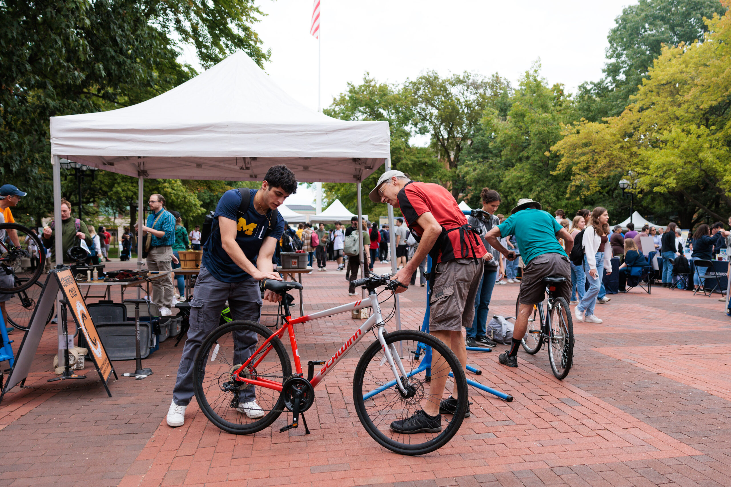 volunteers from a local organization work on bicycles under a white tent during EarthFest 2024.