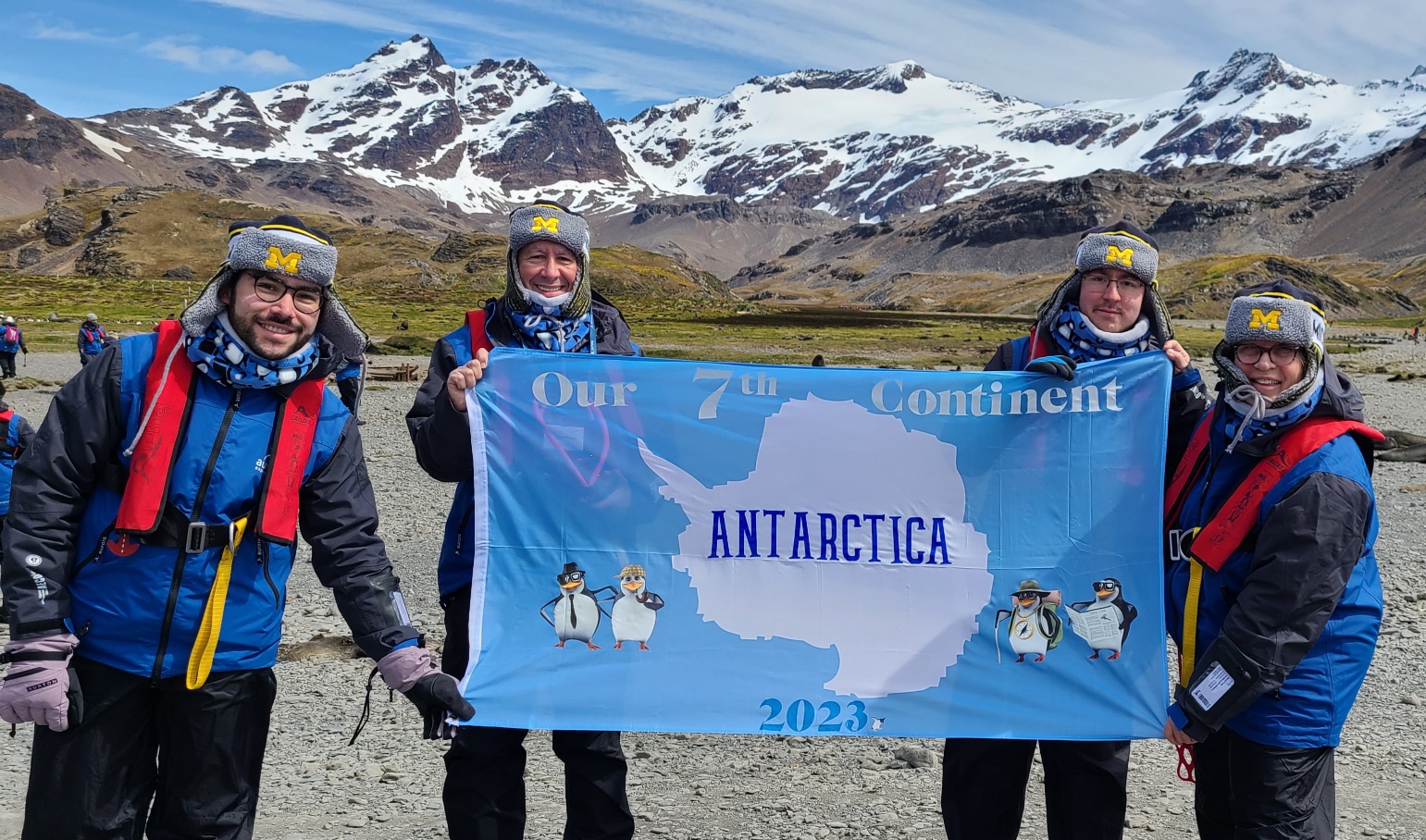 Zachary Shulkin, ’20, Barry Shulkin, MDRES’84, MBA’02, Patresha Mandel, MSW’80, and Jeffrey Shulkin, ’24, posed with their special flag during a stop on South George Island, en route to completing their family goal of visiting all seven continents in December.