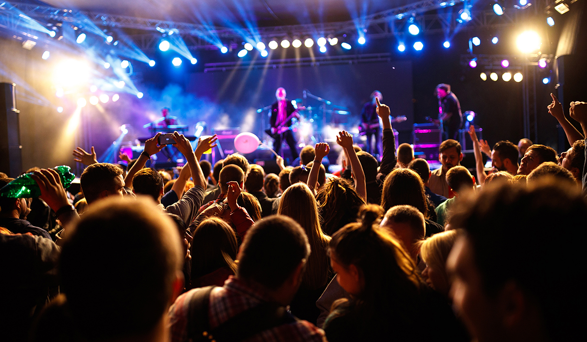 A crowd looks toward the stage as a band performs