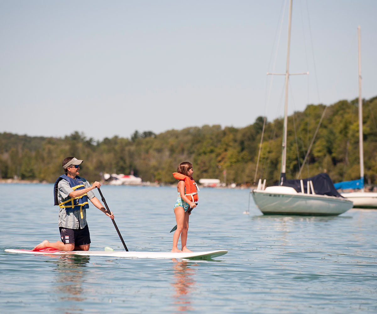 Two people paddle boarding in Walloon Lake