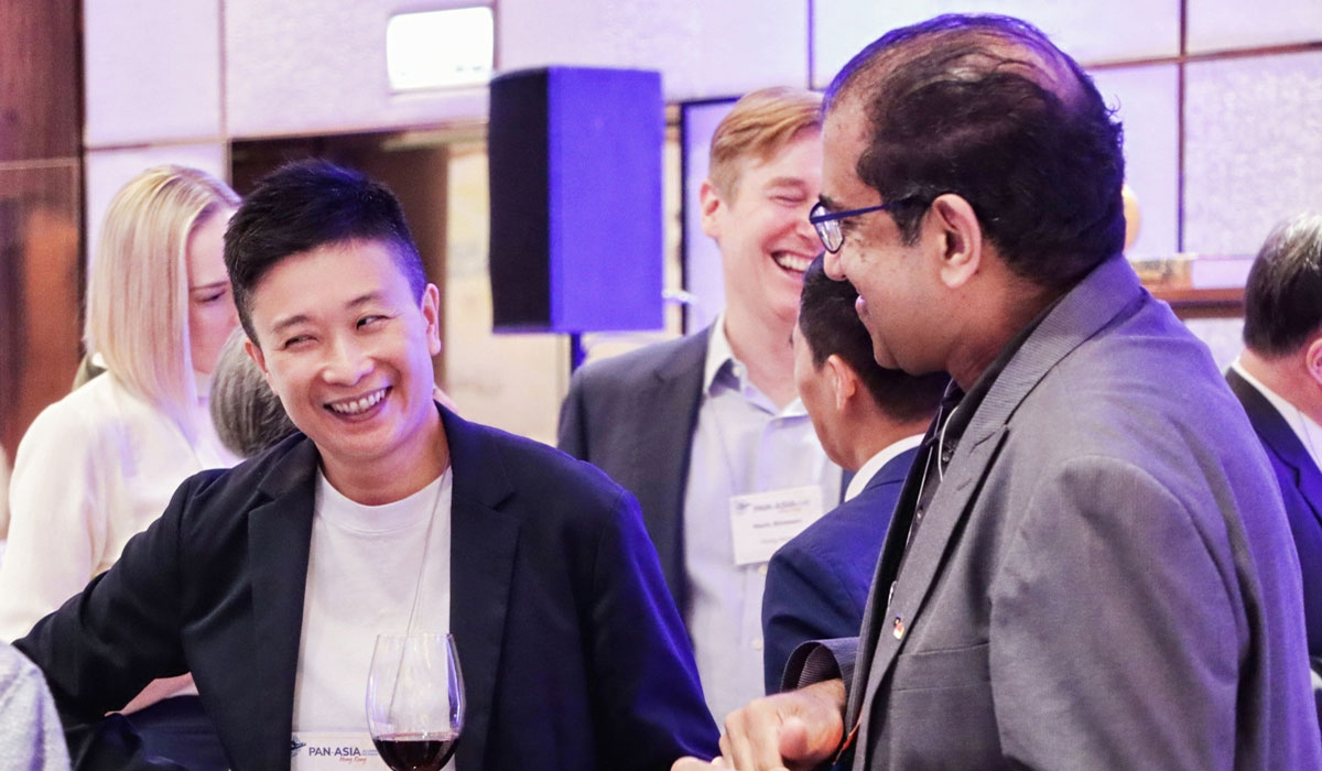 People smile while in conversation at the 2025 Pan-Asia Alumni Reunion.