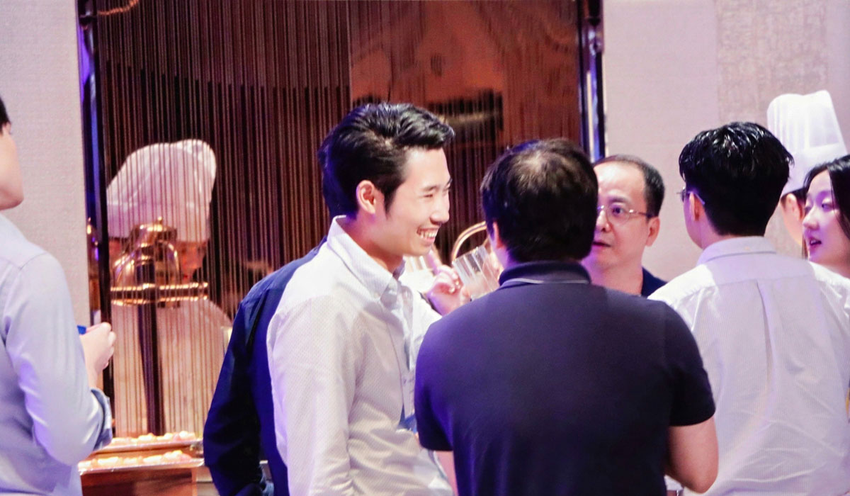 People smile while in conversation at the 2025 Pan-Asia Alumni Reunion.