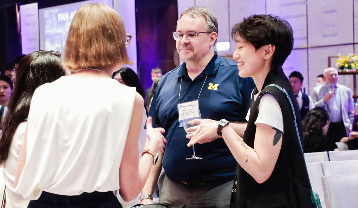 Four people in conversation at the 2025 Pan-Asia Alumni Reunion.