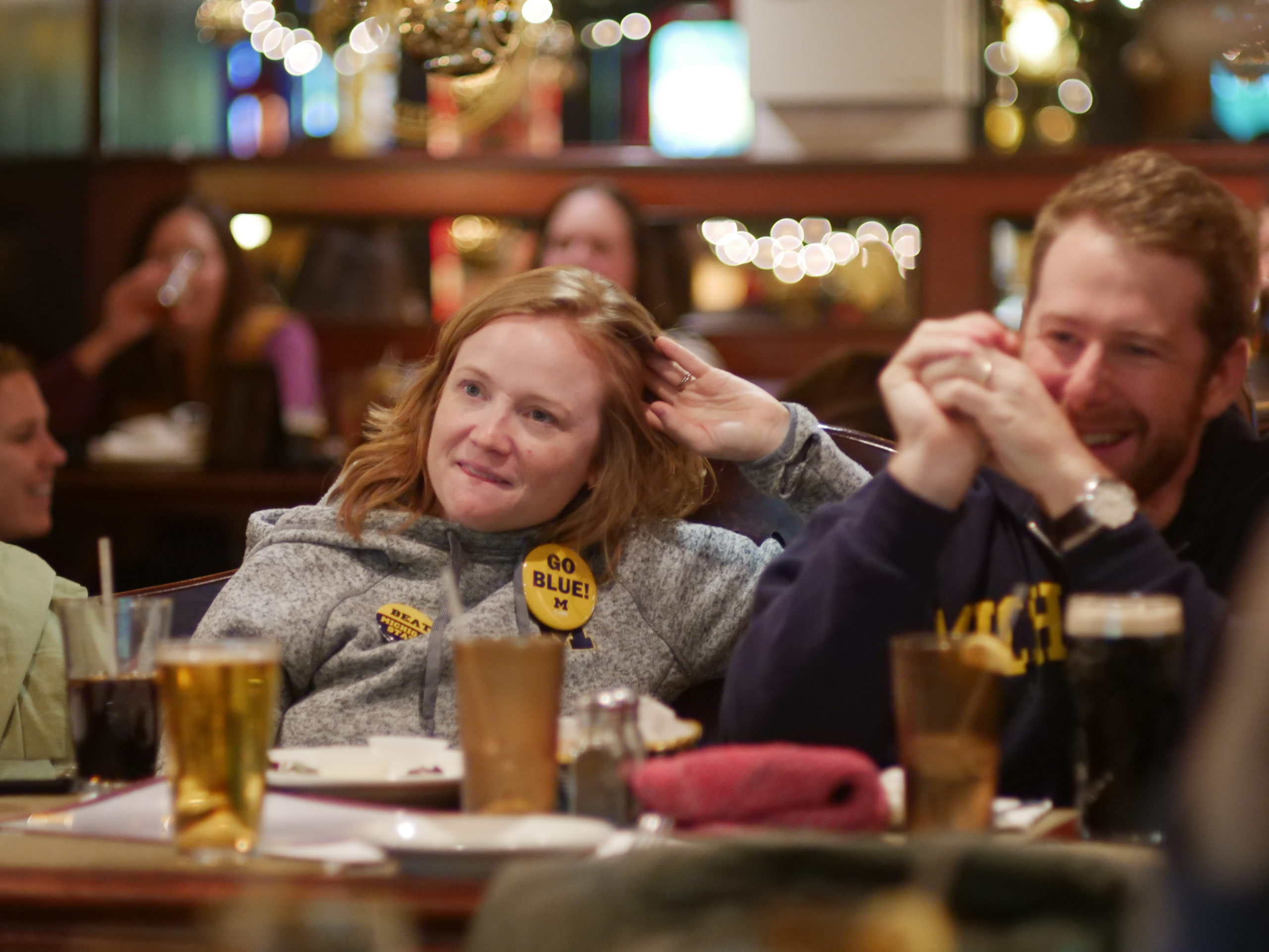 Man and woman in U-M clothing sitting at a restaurant table
