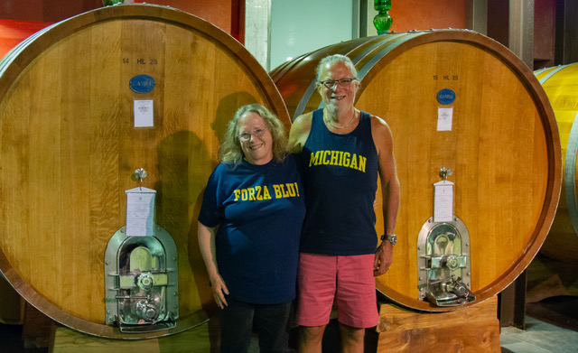 Michael Rembor, ’85, and Carol Rembor, ’87, at Conterno Fantino Winery in Monforte d’Alba, Italy with two large wine-filled barells. Carol is showing her pride in Italian, “Forza Blu!”