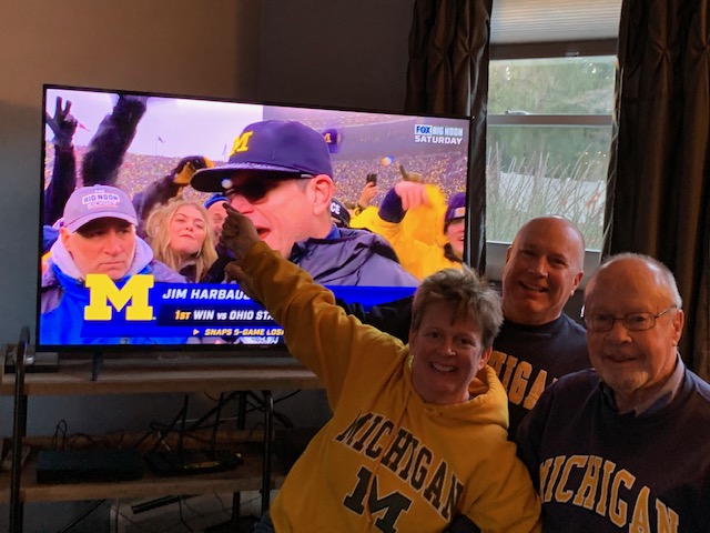 “Team Riddle” celebrated the Wolverines’ victory over the Buckeyes in 2021 during a watch party in Clifton Park, New York. Jack Riddle, ’59, is on the far right, joined by “team kids” Catie and Tom.