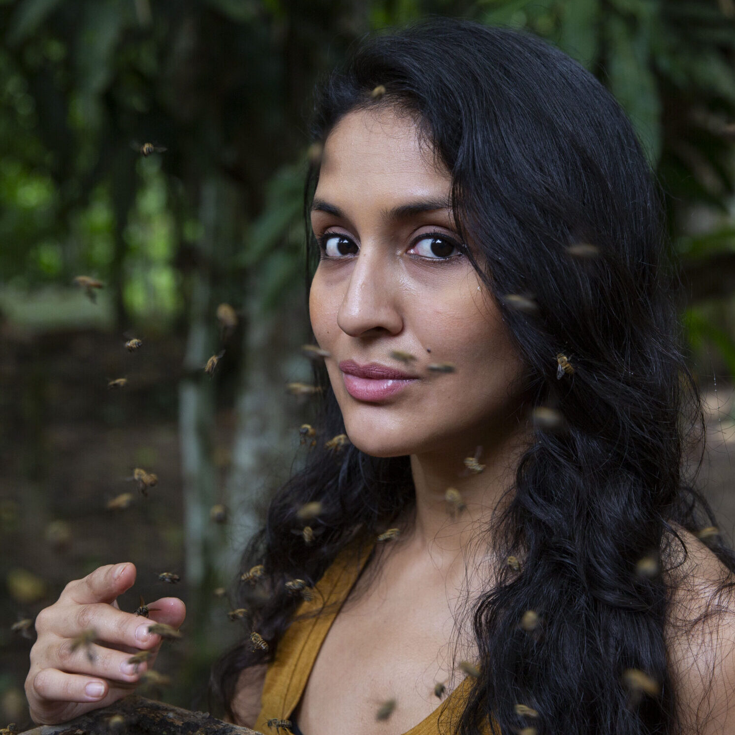 Rosa Vásquez Espinoza poses with Amazonian stingless bees buzzing around her in the Peruvian rainforest.