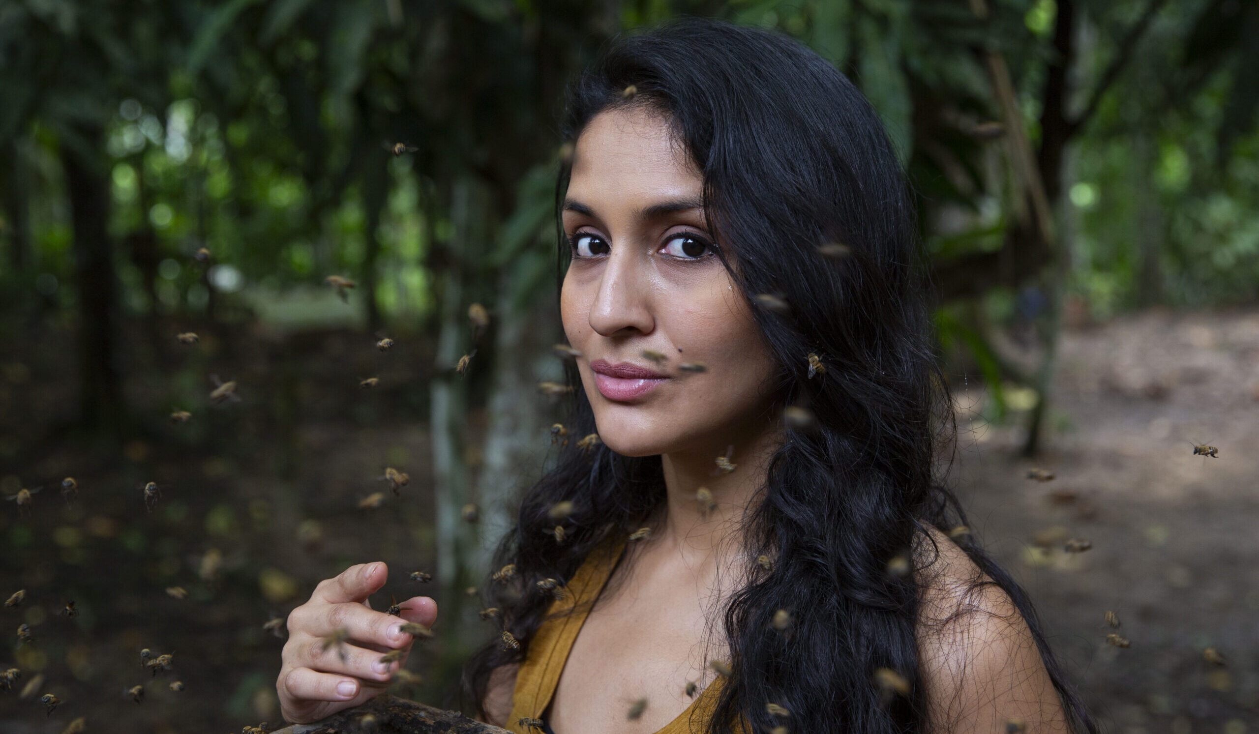 Rosa Vásquez Espinoza poses with Amazonian stingless bees buzzing around her in the Peruvian rainforest.