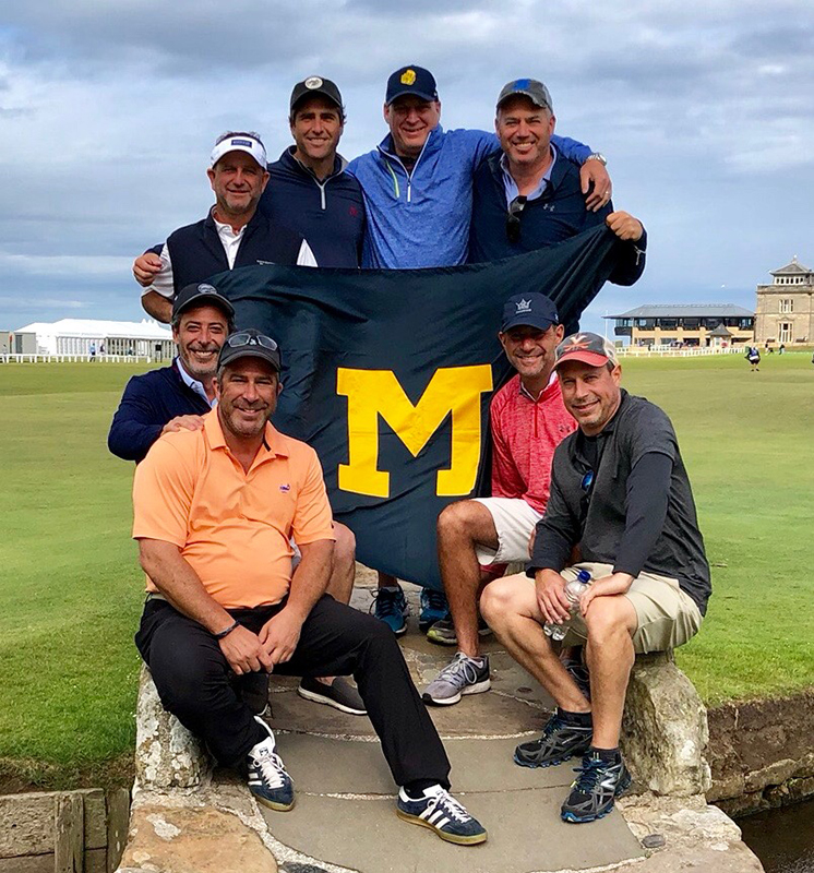 Daniel Roshco, ’90 (in front of flag, farthest to the left), celebrated his50th birthday with a golf outing at the Old Course at St Andrews, Scotland.