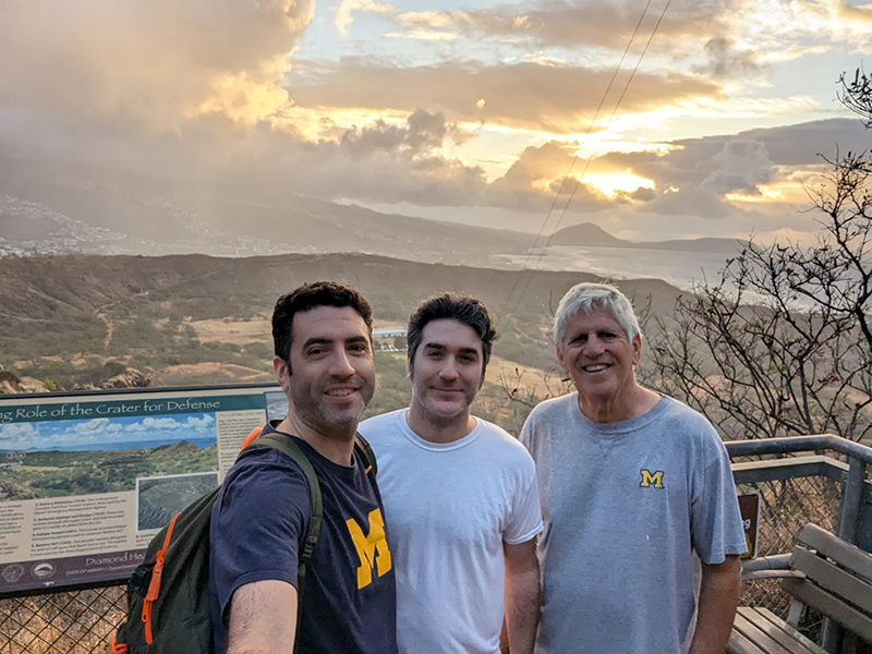 Greeting the sunrise from the top of Diamondhead Crater in Honolulu, Hawaii, in April are Mark Shuster, ’05, his brother, Gary, and their father, Steven Shuster, ’73, DDS’75.