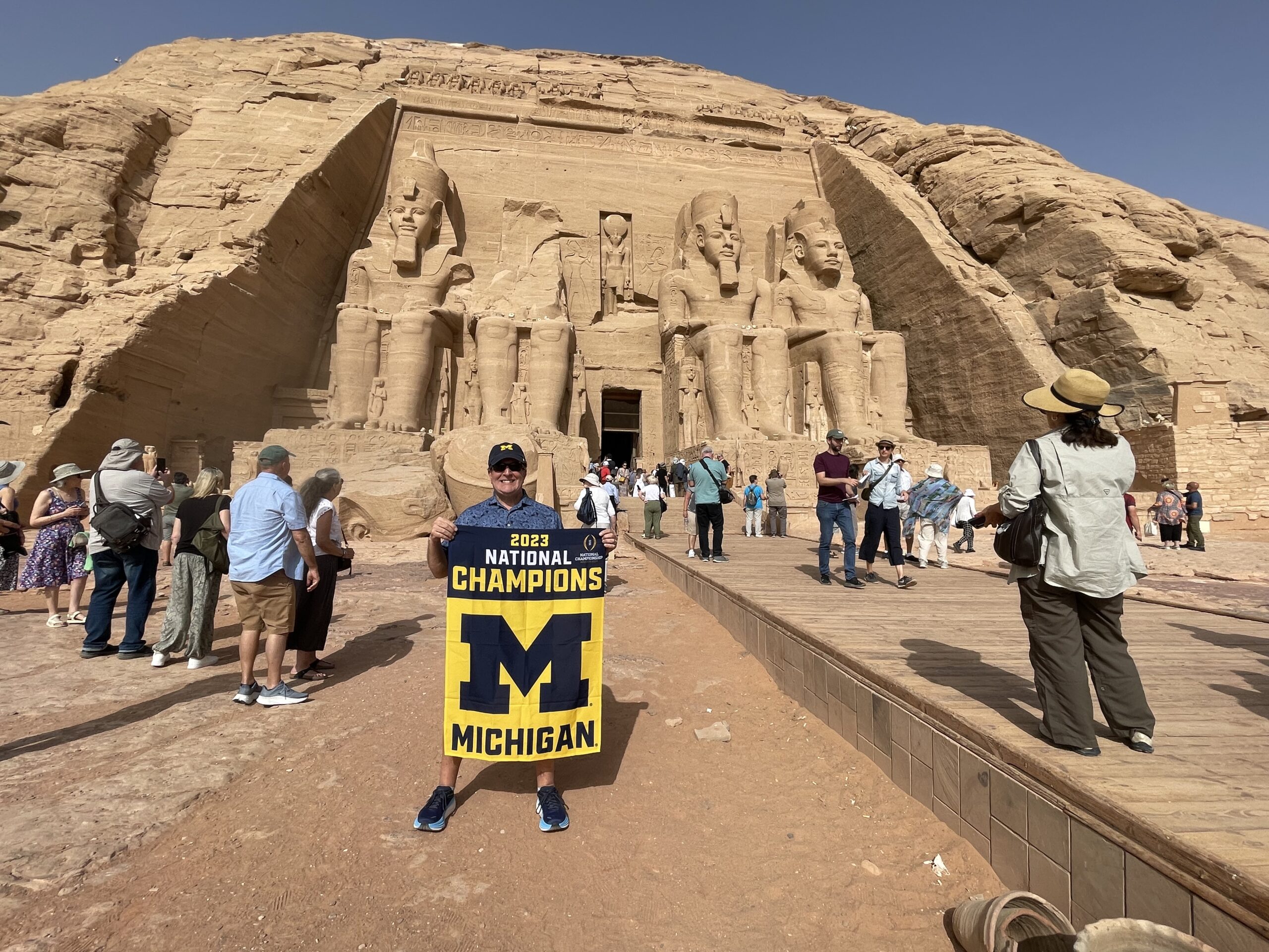 Tom Mathews, MBA’84, unfurled his U-M flag at the feet of the giant statues of the Great Temple of Ramesses II in Abu Simbel, Egypt.