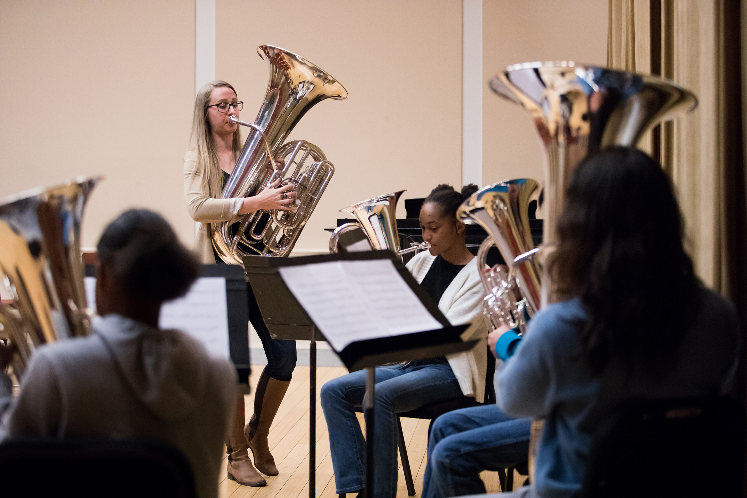 Carol Jantsch plays the tuba with a music class of students playing tubas. 