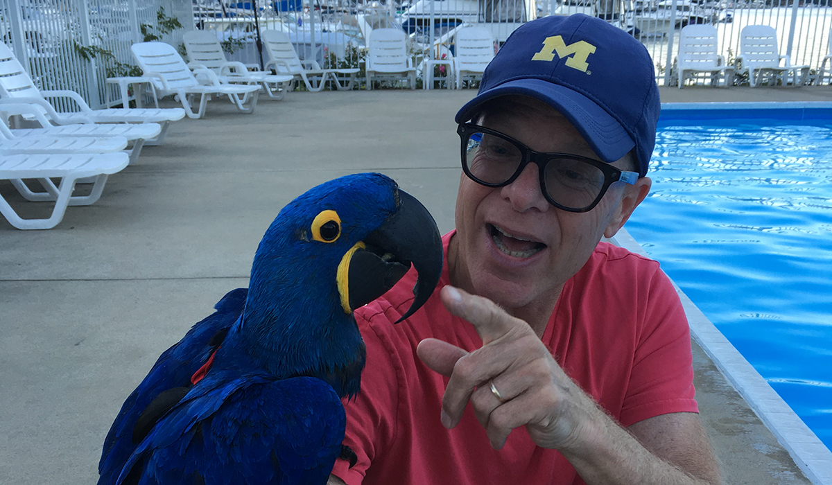Wolverines of a feather flock together, as demonstrated by Steve Saginaw, ’74, and his fine-feathered companion at Steve’s condominium association pool in Saugatuck, Michigan.