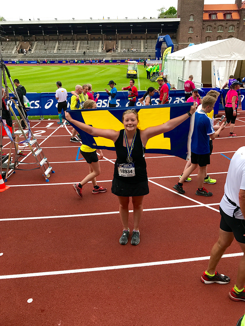 Mackenzie Melvin, ’11, at the finish line of the 2017 Stockholm Marathon in Sweden. The final leg of the race was a lap inside the Stockholm Olympic Stadium.
