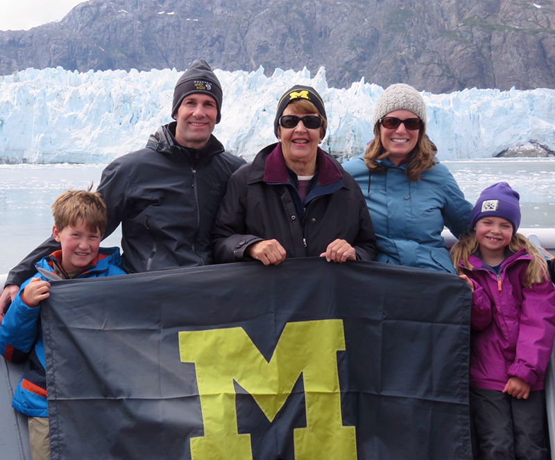 The Champion (actual surname) Family–Greg, ’90, Alice, ’64, MA’67, Jen, and future Wolverines Connor and Ella–show their U-M support at Margerie Glacier in Glacier Bay National Park, Alaska, with Canada bordering just beyond to the north.
