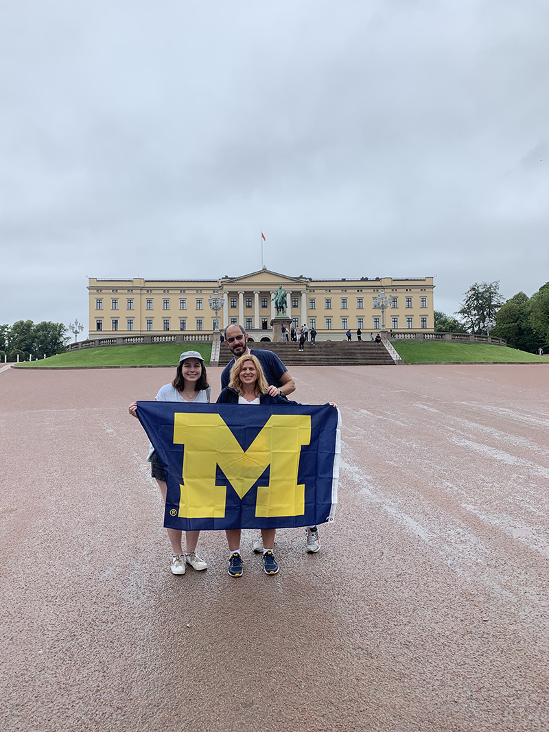Meredith Weingarden, ’91, her husband, Adam, and their daughter, Emilie, showed off their U-M flag in front of the Royal Palace in Oslo, Norway, in August. Missing from the picture is her son, Noah, who is a current U-M student.