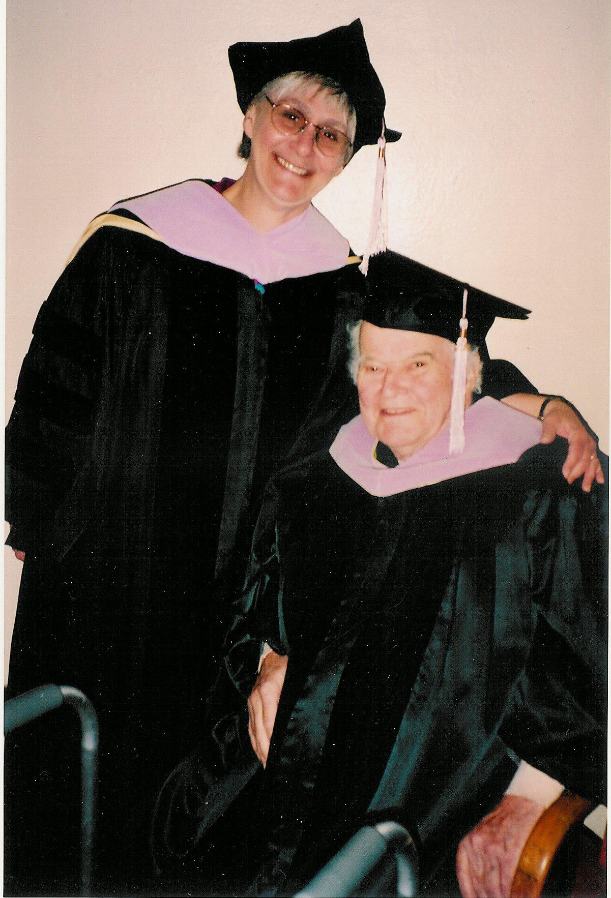 A home photo of Sharon Brooks and Dr. Albert Richards, both in black commencement attire.
