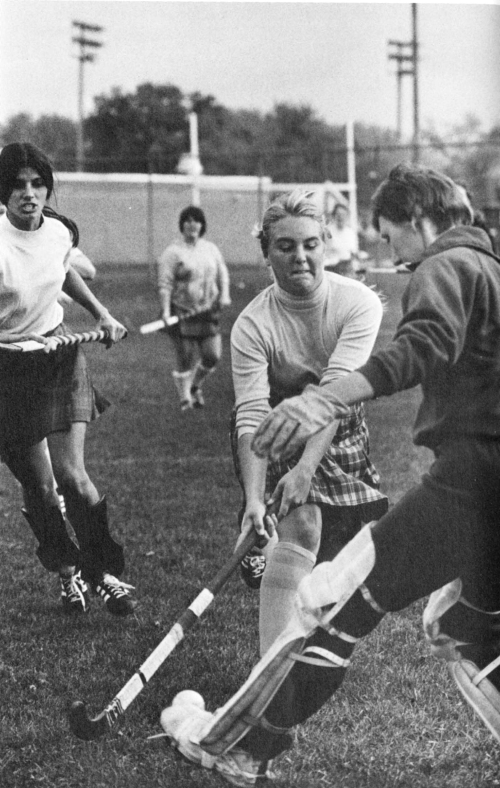From 1975, four girls playing field hockey at U-M