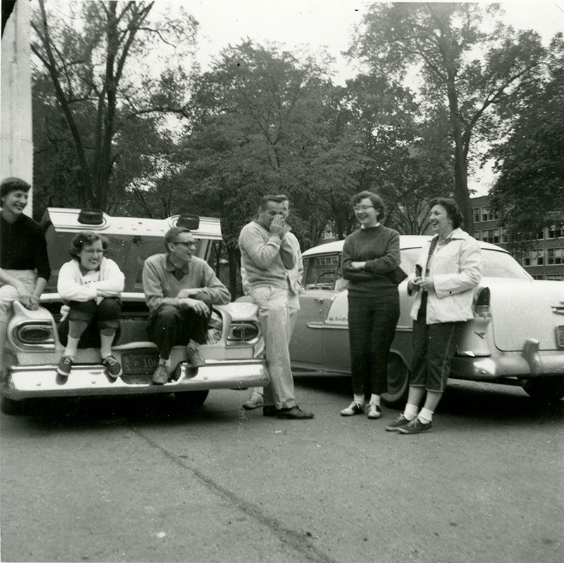 1959: As time went on, the car ban included more and more exemptions. Students who were over 28 years old, married, or studying part time were allowed cars on campus. These students, gathered around cars outside Angell Hall, may have fallen into one of these categories.