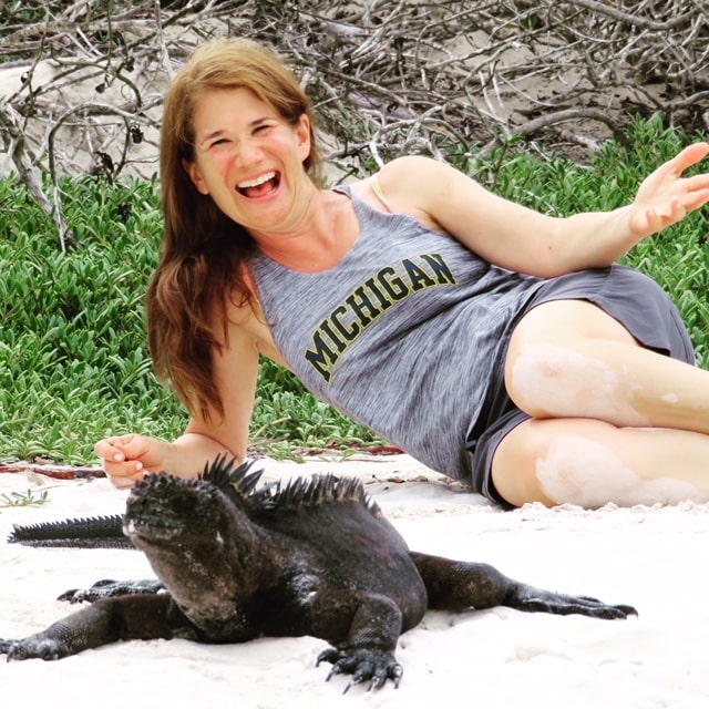 Sheryl Biesman, ’87, and her new pal, a marine iguana, enjoyed the sun on the beaches of the Galápagos Islands.