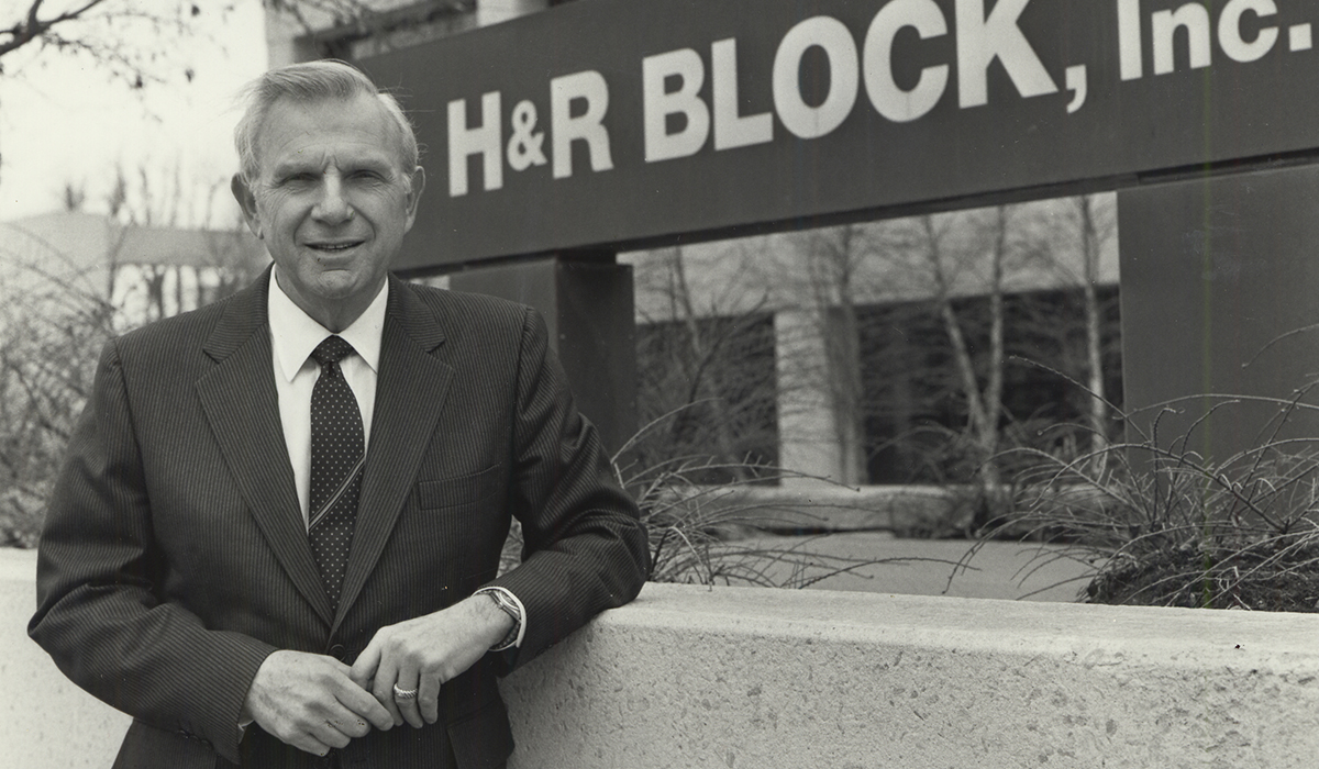 Black-and-white photo of Henry Bloch outside an H&R Block office building in 1975