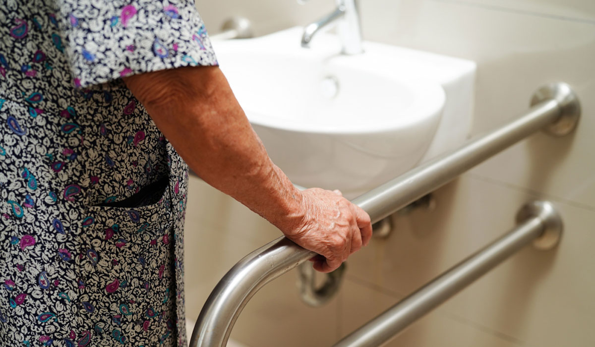 V2older Woman Holding Grab Bar In Bathroom