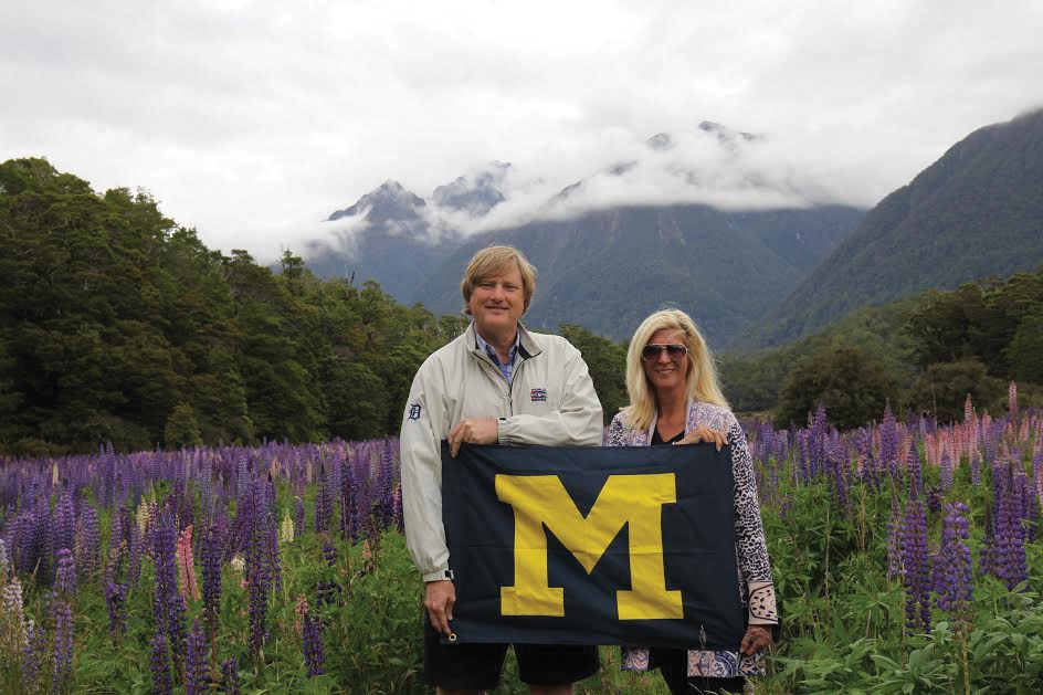 In the midst of a meadow of lavender lupine flowers in New Zealand’s Fiordland National Park, Paul S. Hoge, ’81, and wife Janann display a spot of Maize and Blue.