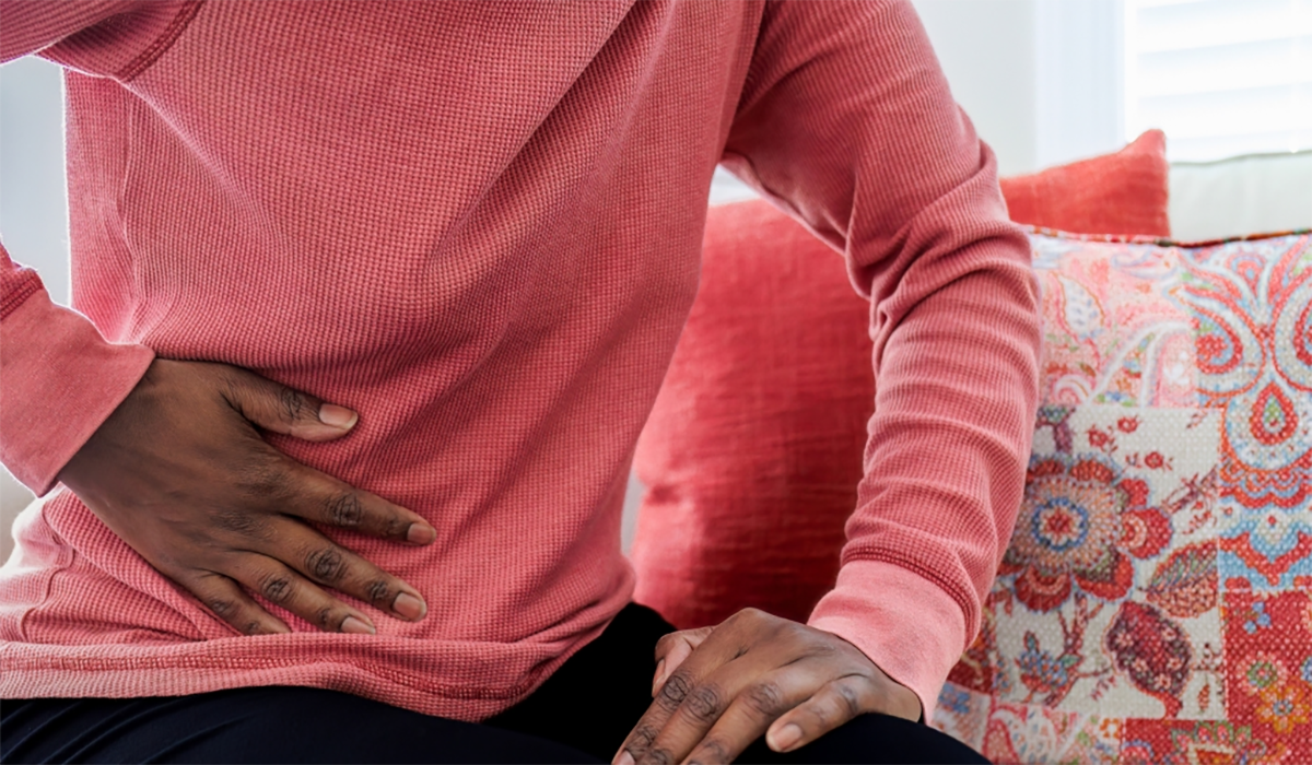 Woman Holding Abdomen Pink Sweater